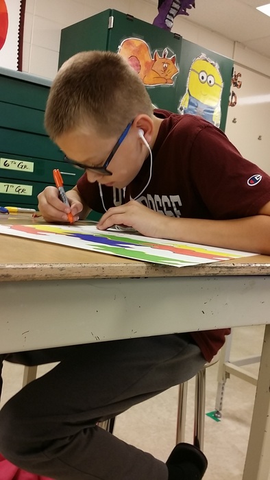 7th grade student very focused on his drawing assignment in art